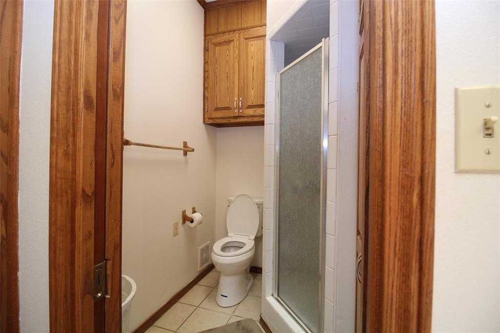 220 North 14th Avenue Munday, TX 76371 - Photo 15 of 34 a bathroom with a toilet and a shower
