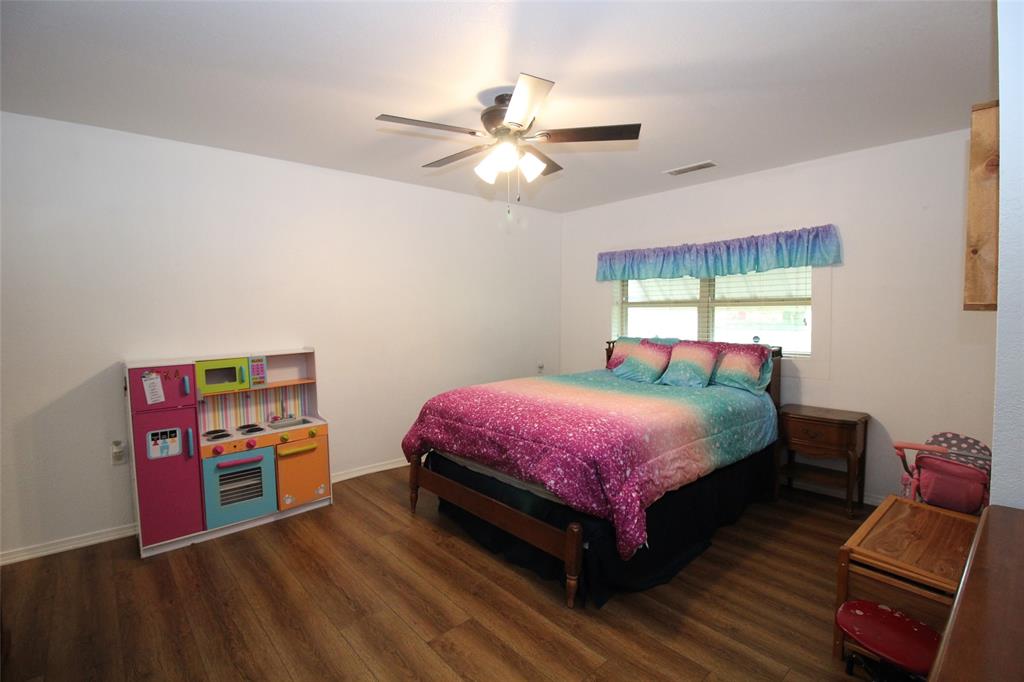 220 North 14th Avenue Munday, TX 76371 - Photo 17 of 34 a bedroom with a bed and a chandelier