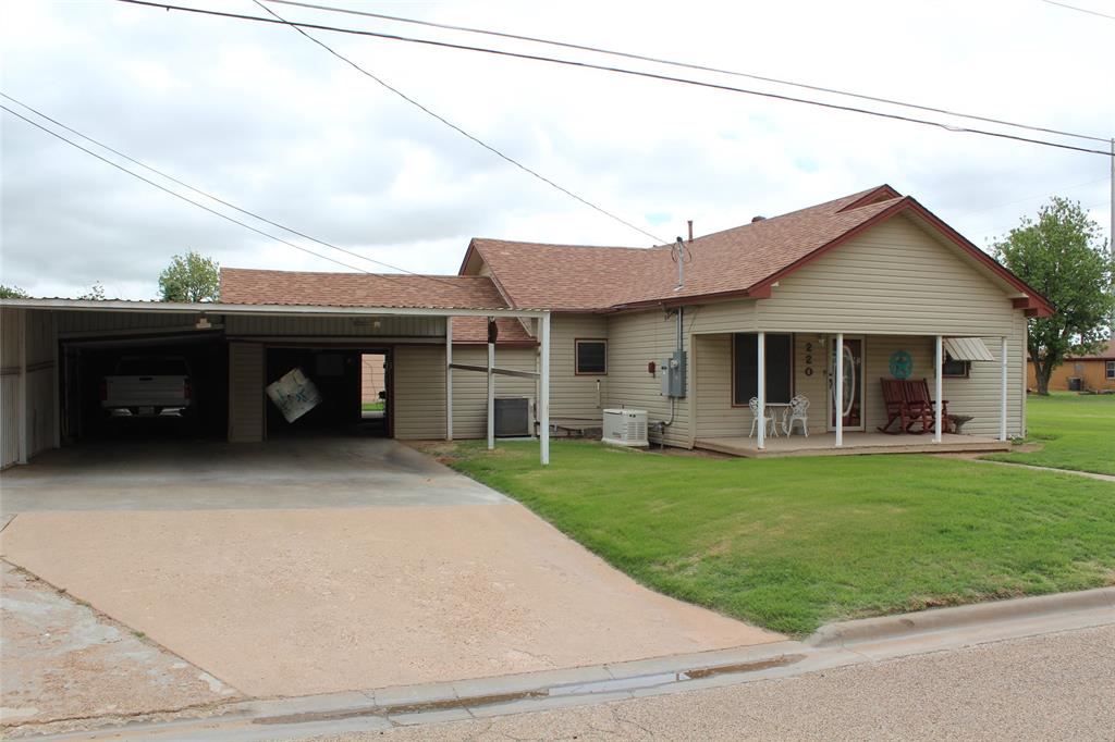220 North 14th Avenue Munday, TX 76371 - Photo 2 of 34 a front view of a house with a garden and porch