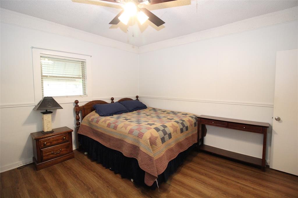 220 North 14th Avenue Munday, TX 76371 - Photo 21 of 34 a bedroom with a bed and a chandelier