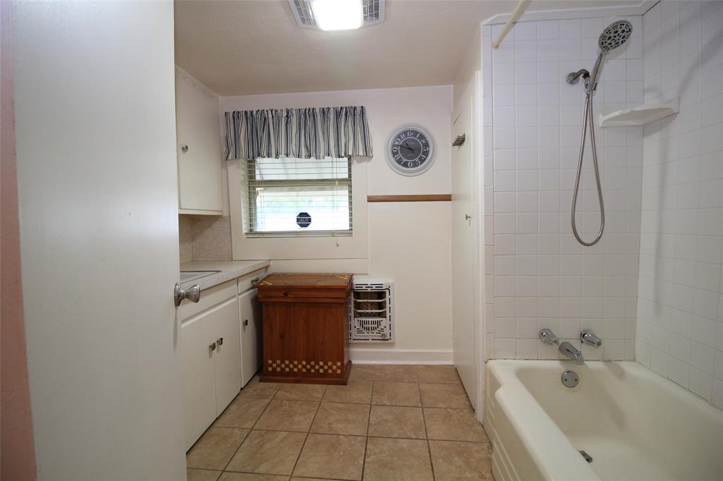 220 North 14th Avenue Munday, TX 76371 - Photo 22 of 34 a bathroom with a bathtub sink and mirror