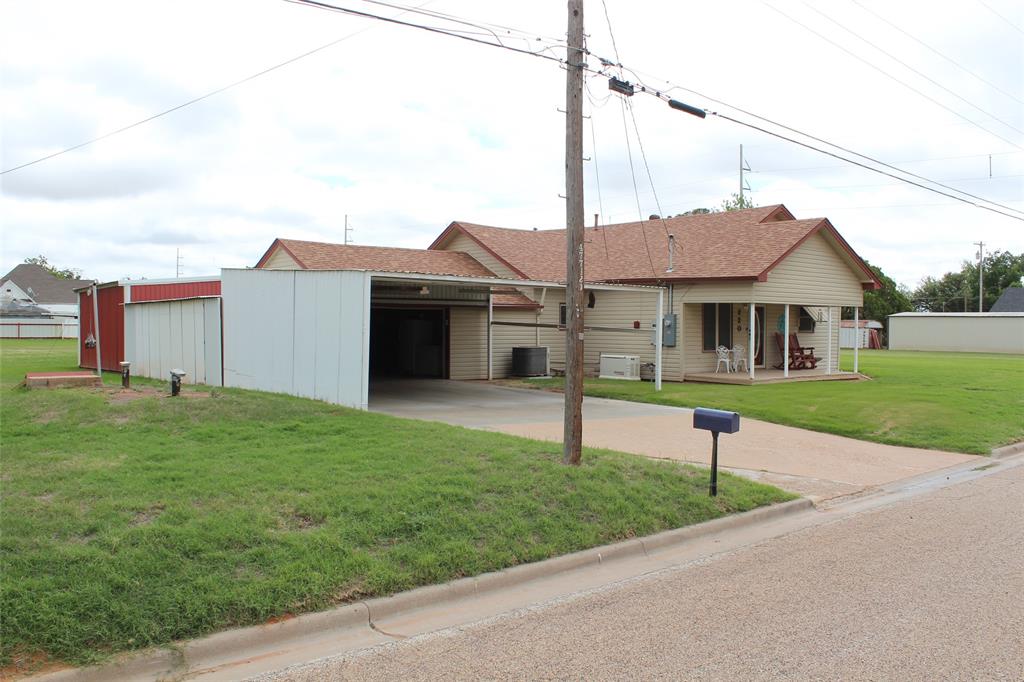 220 North 14th Avenue Munday, TX 76371 - Photo 3 of 34 a front view of a house with a garden and yard