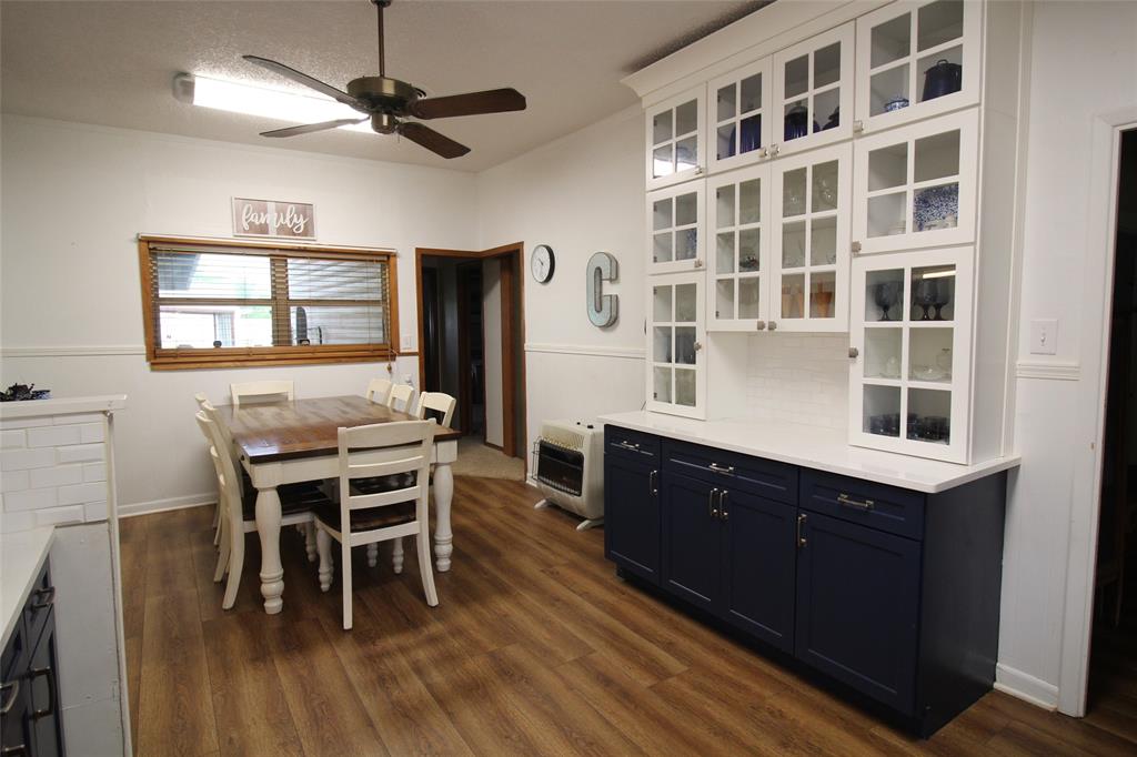 220 North 14th Avenue Munday, TX 76371 - Photo 10 of 34 a kitchen with a dining table chairs and cabinets