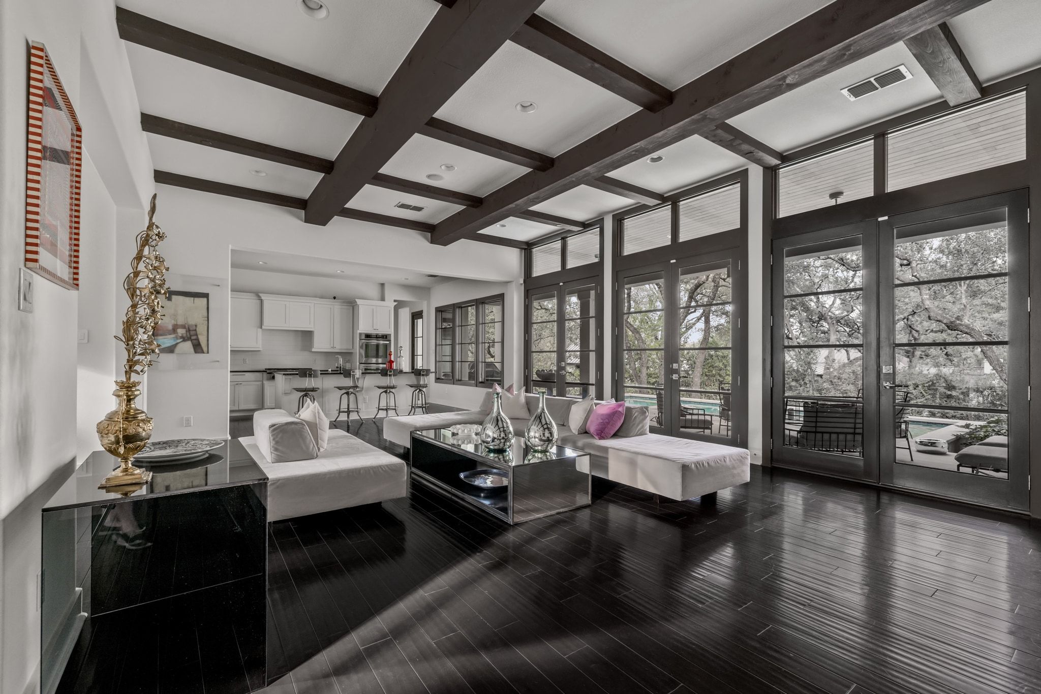 4720 Rockcliff Road, Unit 1 Austin, TX 78746 - Photo 14 of 39 Bold beamed ceilings and dark wood floors define this expansive living area, opening to outdoor leisure.
