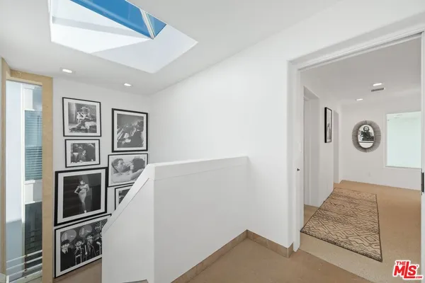 a view of a hallway with bathroom and shower