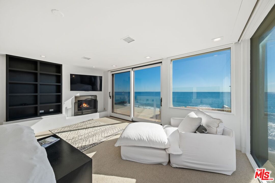 25302 Malibu Road Malibu, CA 90265 - Photo 17 of 36 a living room with furniture a flat screen tv and a fireplace