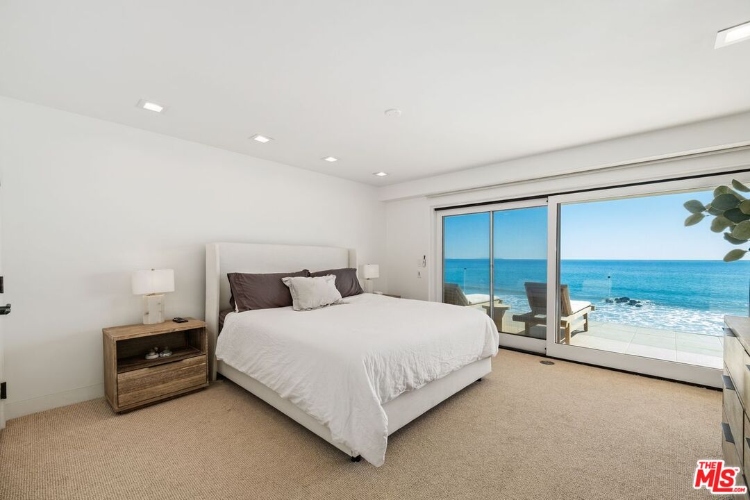 25302 Malibu Road Malibu, CA 90265 - Photo 21 of 36 a bedroom with a bed and large window