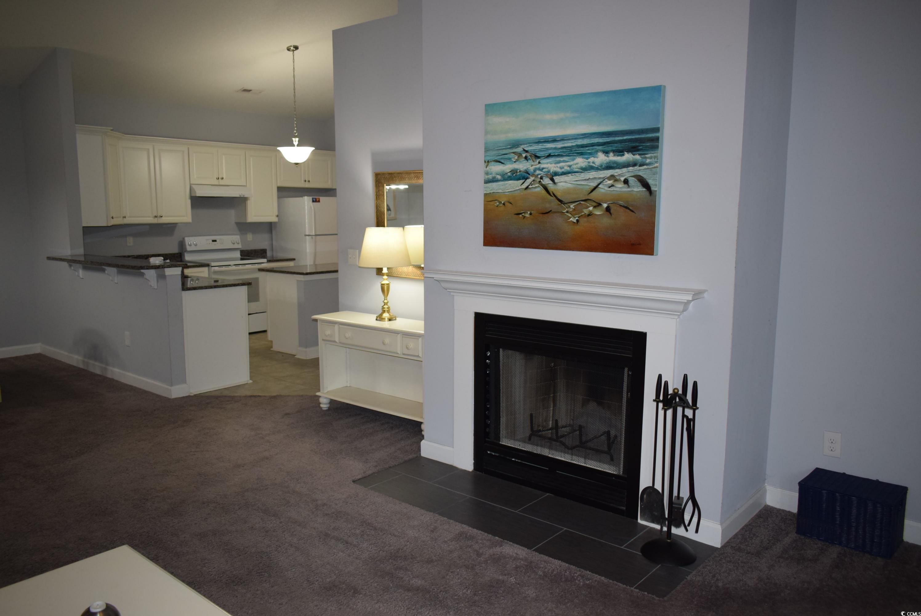 216 Rose Water Loop Myrtle Beach, SC 29588 - Photo 13 of 40 Living area featuring dark colored carpet and a fireplace with flush hearth