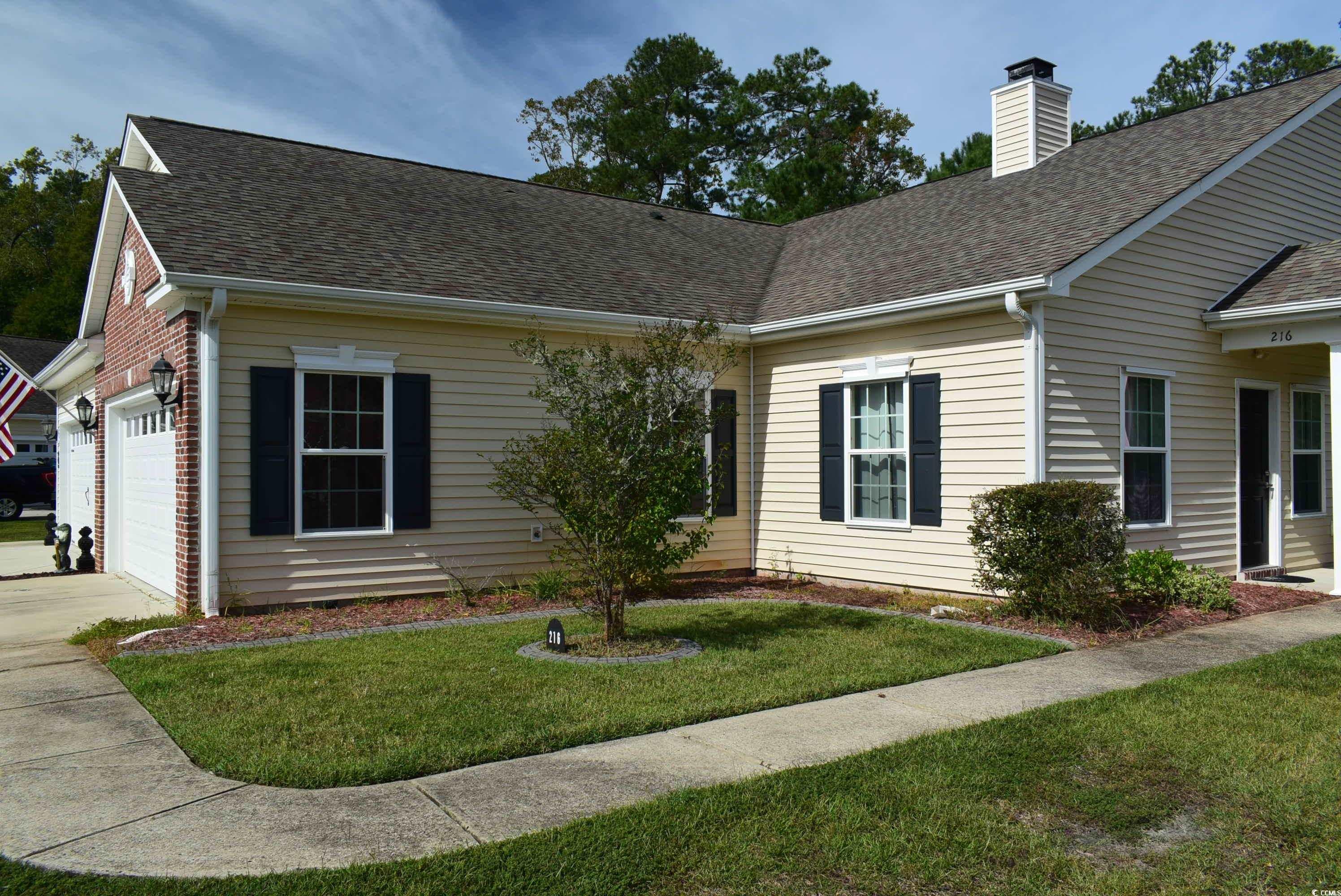 216 Rose Water Loop Myrtle Beach, SC 29588 - Photo 2 of 40 View of front of property with a front lawn, a shingled roof, a chimney, and driveway