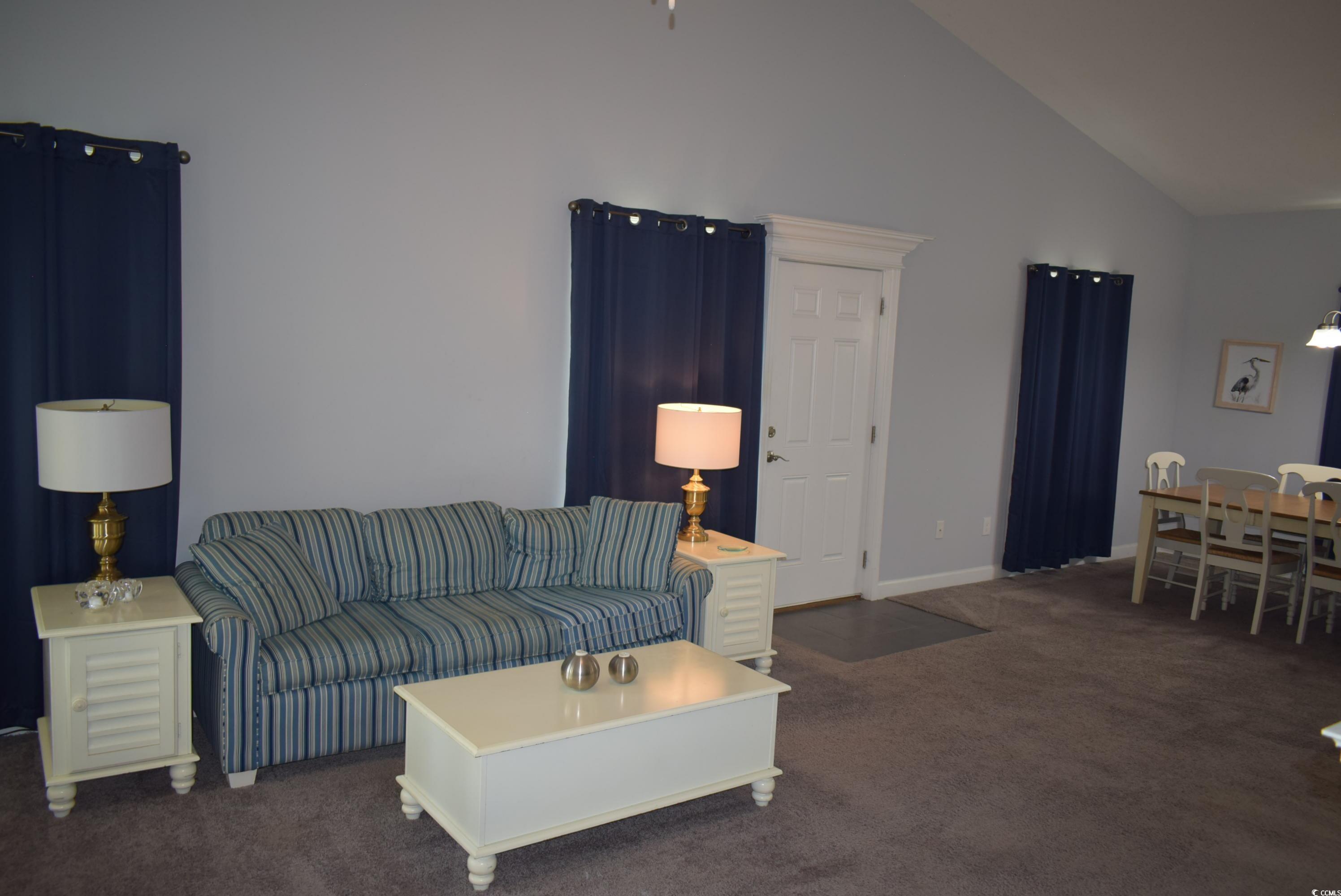 216 Rose Water Loop Myrtle Beach, SC 29588 - Photo 22 of 40 Carpeted living room featuring high vaulted ceiling and baseboards