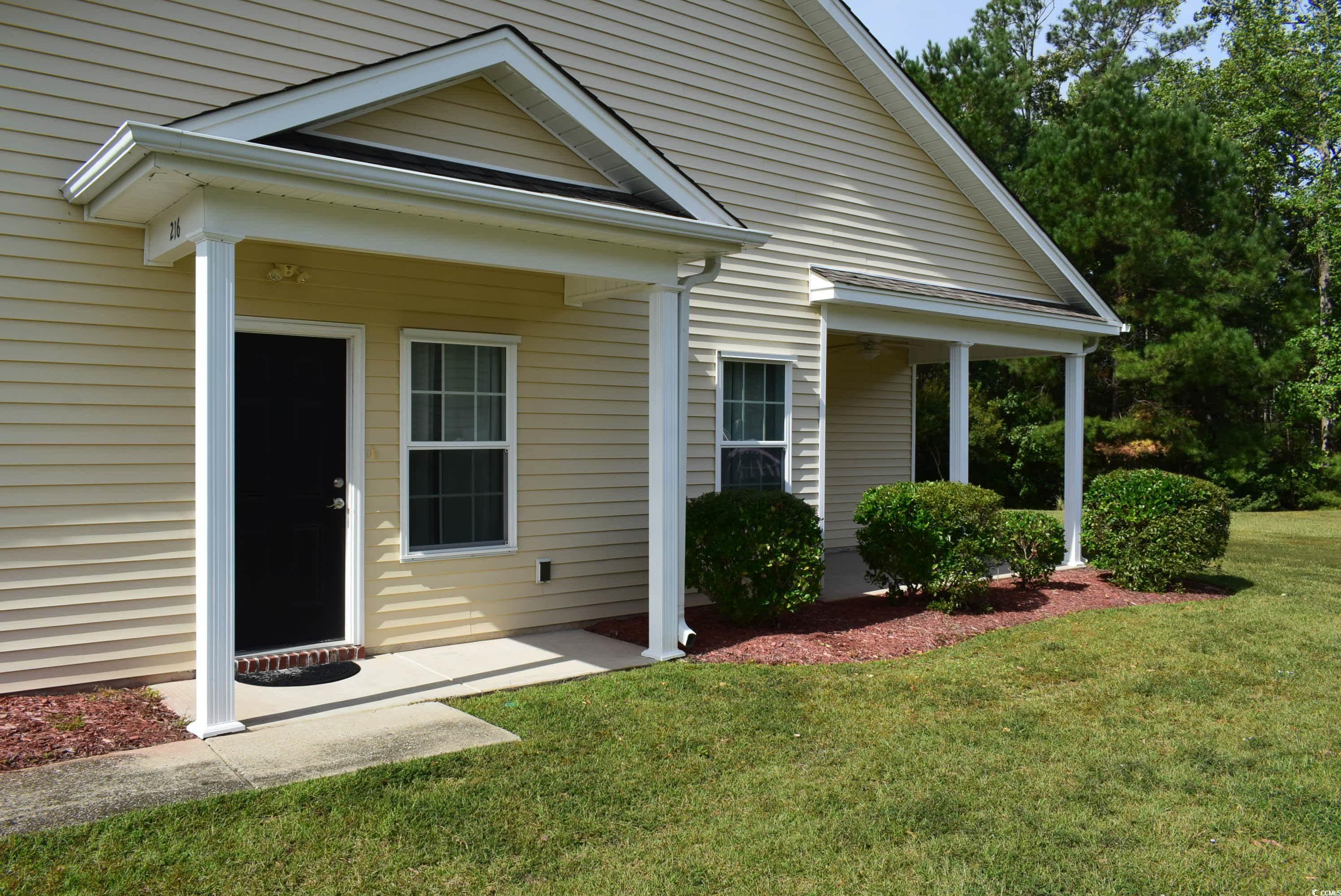 216 Rose Water Loop Myrtle Beach, SC 29588 - Photo 3 of 40 View of exterior entry featuring covered porch and a yard