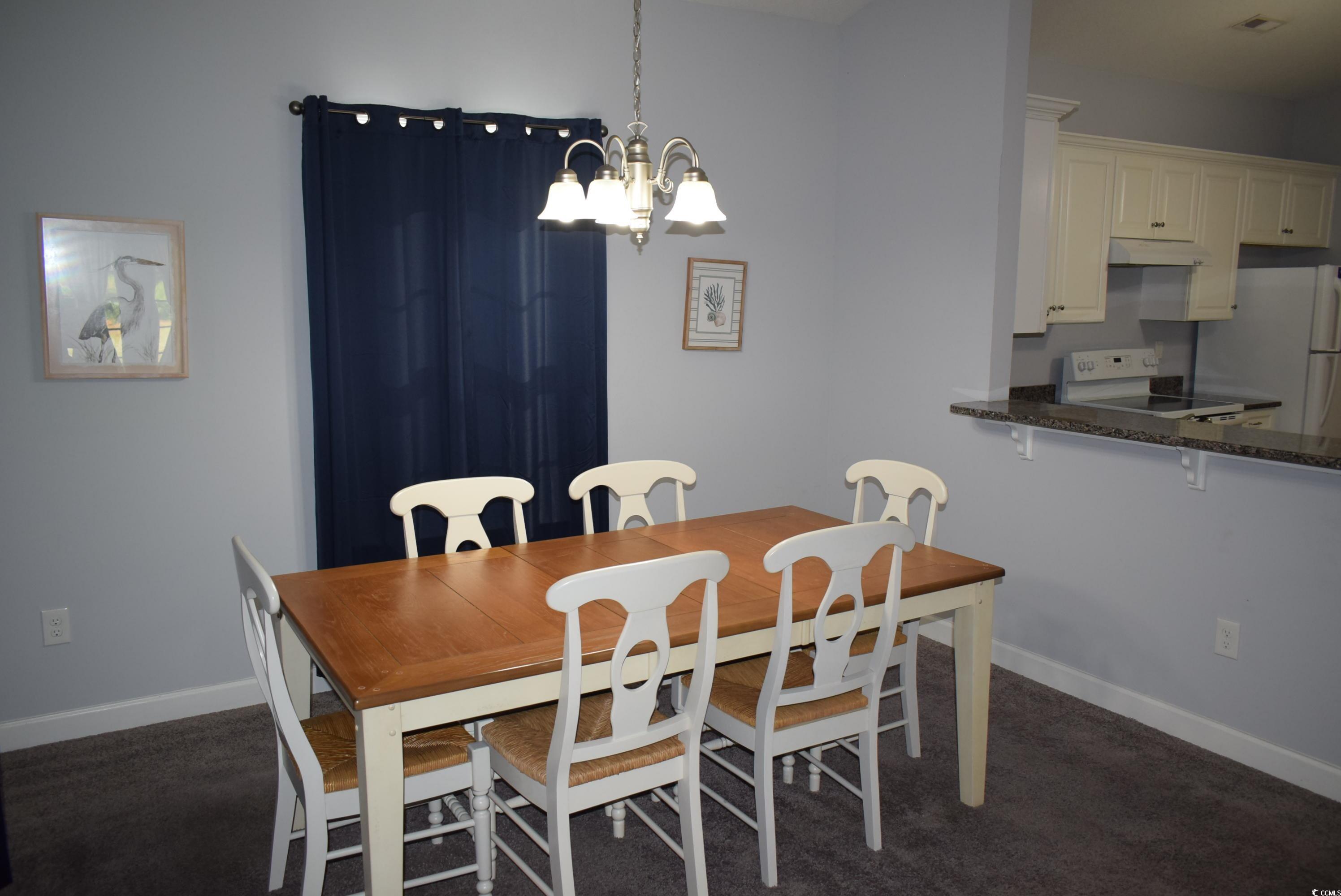 216 Rose Water Loop Myrtle Beach, SC 29588 - Photo 7 of 40 Dining space with a chandelier and dark carpet