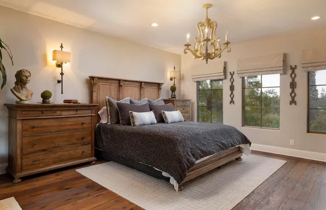 a spacious bedroom with a balcony a bed and a chandelier