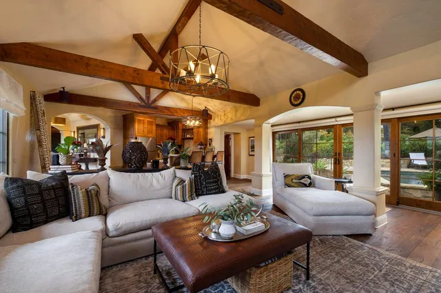 a living room with furniture kitchen view and a large window