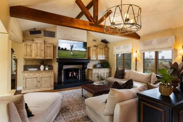 a living room with furniture a fireplace and a chandelier