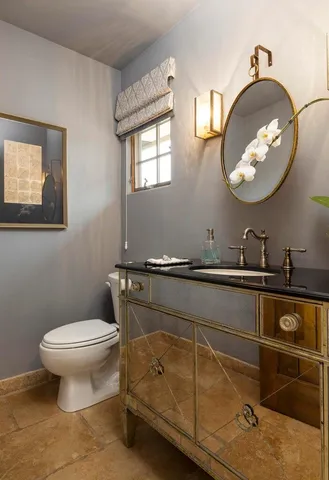 a bathroom with a toilet a sink and mirror