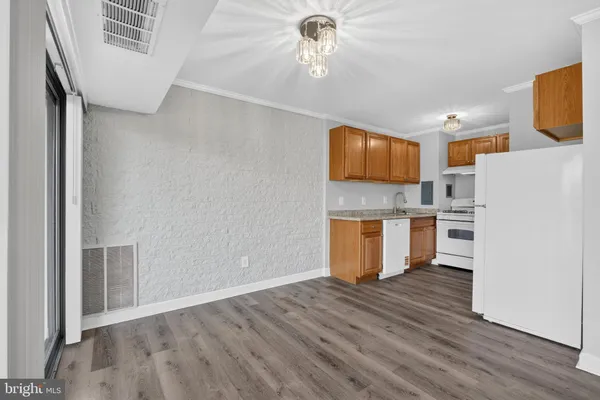 a view of a kitchen with wooden floor and electronic appliances