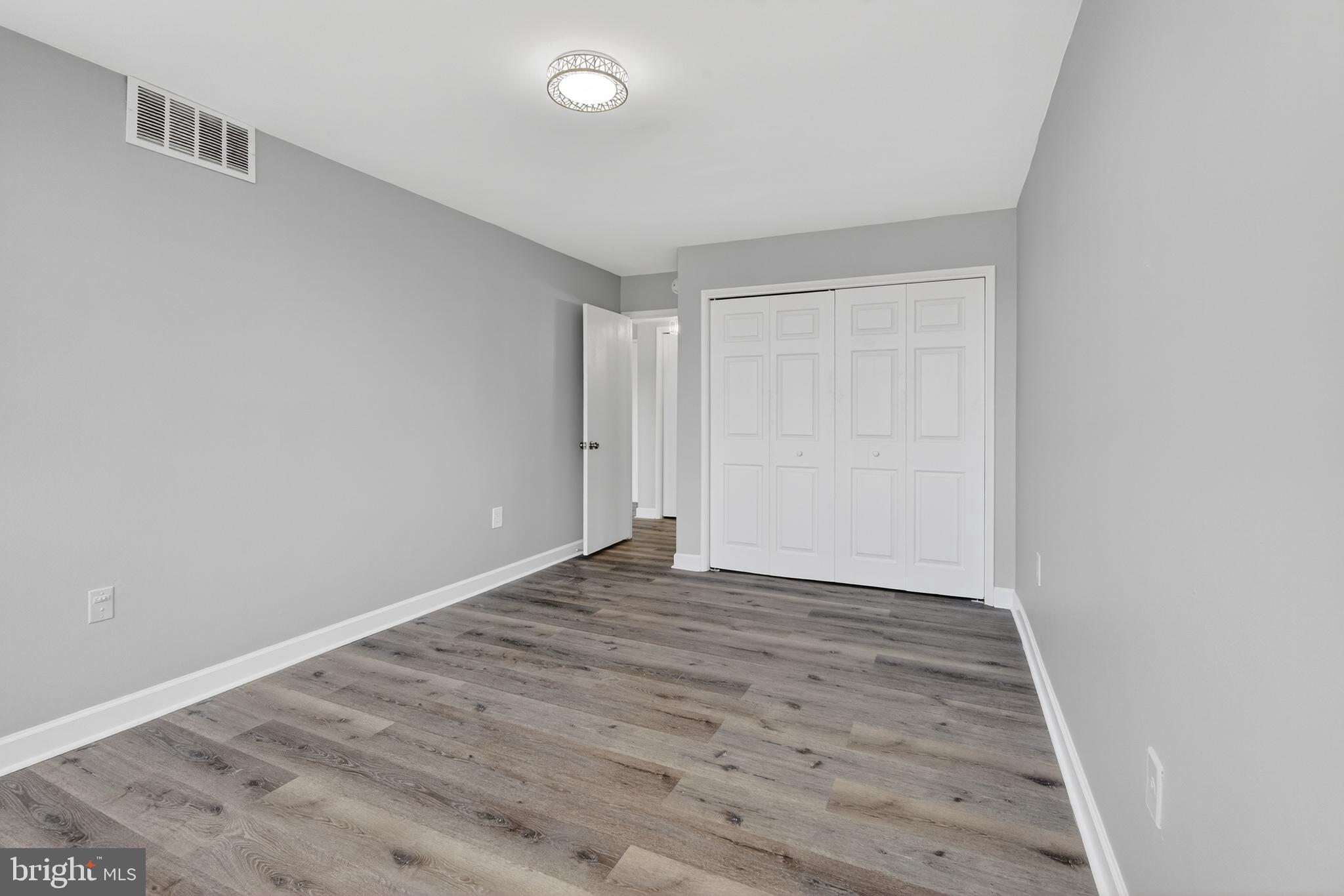 1804 Metzerott Road, Unit 504 Silver Spring, MD 20903 - Photo 23 of 24 a view of an empty room with wooden floor and a window