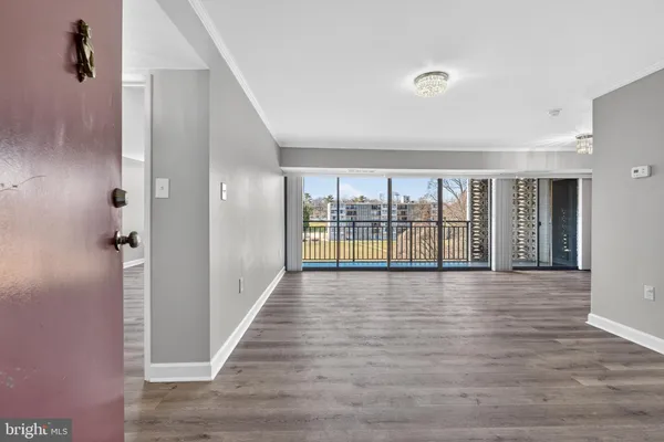 a view of an empty room with wooden floor and closet