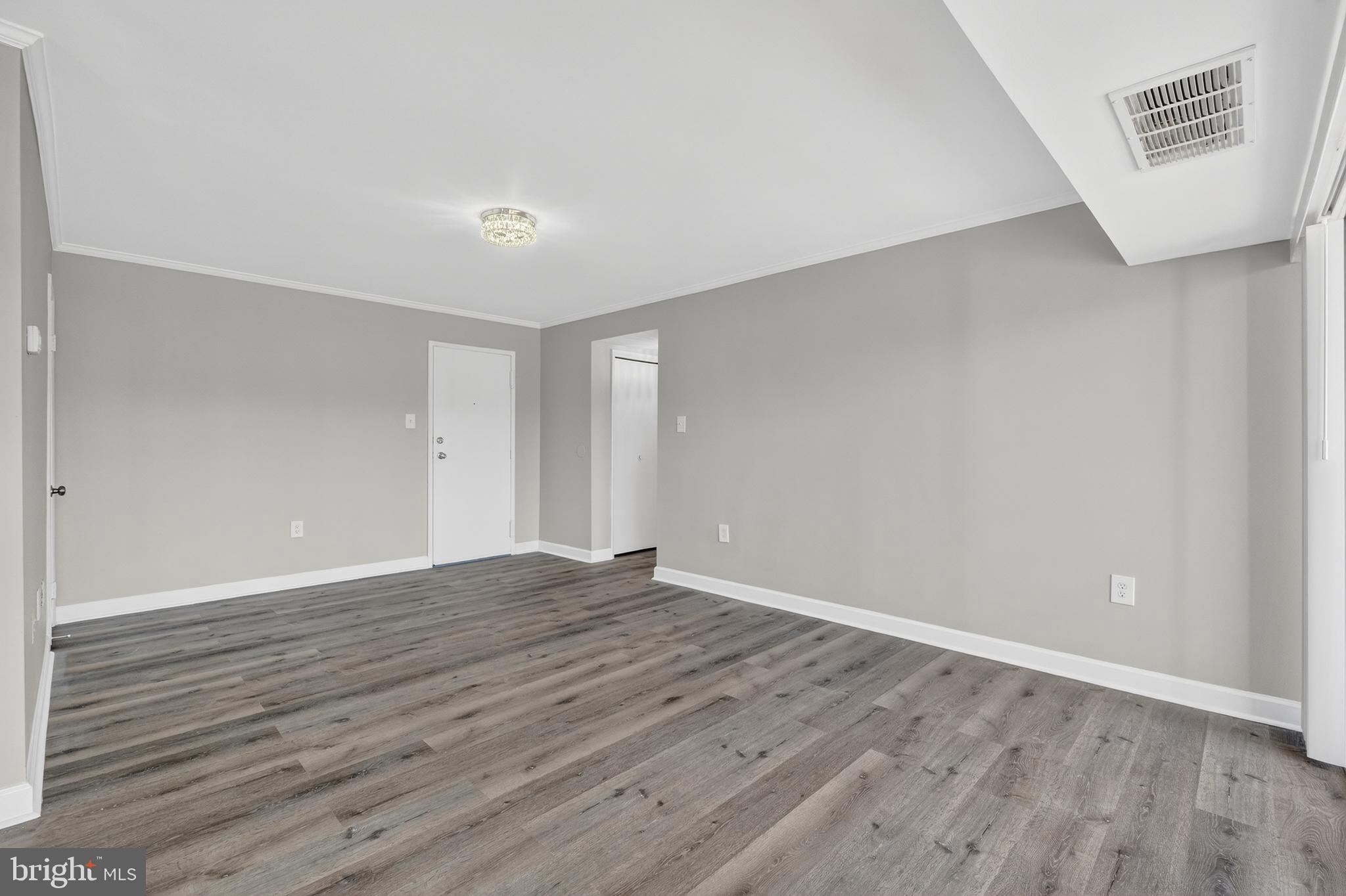 1804 Metzerott Road, Unit 504 Silver Spring, MD 20903 - Photo 10 of 24 a view of an empty room with wooden floor and a window