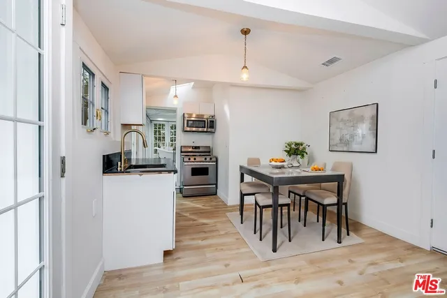 a kitchen with stainless steel appliances kitchen island a refrigerator and a dining table