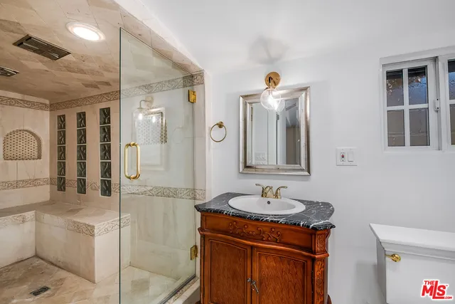 a bathroom with a sink a toilet and shower