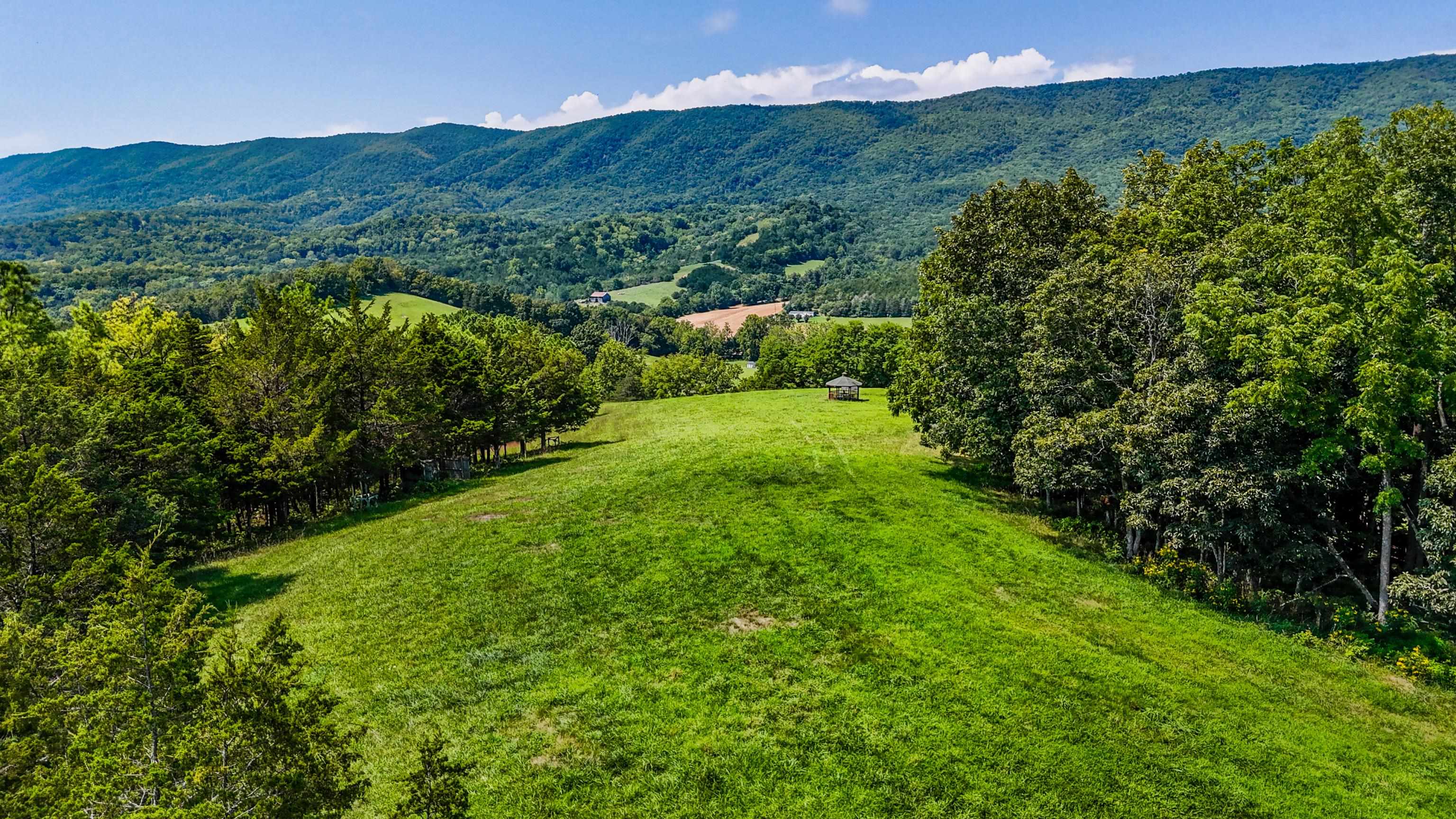 1202 Walkers Creek Road Middlebrook, VA 24459 - Photo 73 of 74 a view of a lush green hillside and a building