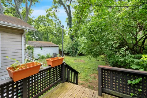 a backyard of a house with wooden floor barbeque oven and yard