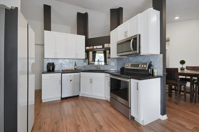 a kitchen with stainless steel appliances granite countertop a stove a sink and a microwave