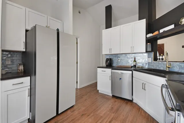 a kitchen with stainless steel appliances a refrigerator sink and cabinets