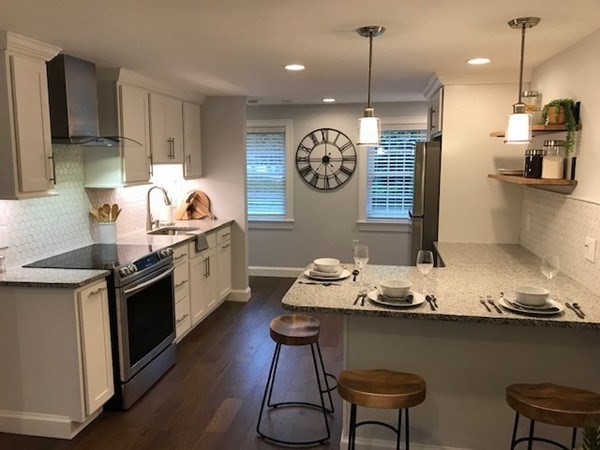 685 Pond Street, Unit B Franklin, MA 02038 - Photo 6 of 11 a kitchen with granite countertop a sink cabinets and stainless steel appliances