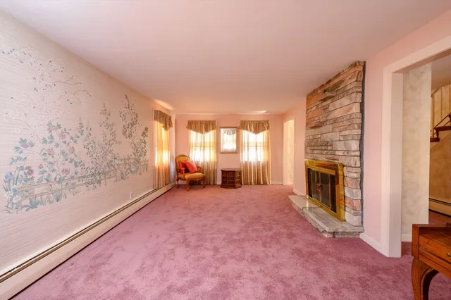 a view of a livingroom with a fireplace and window
