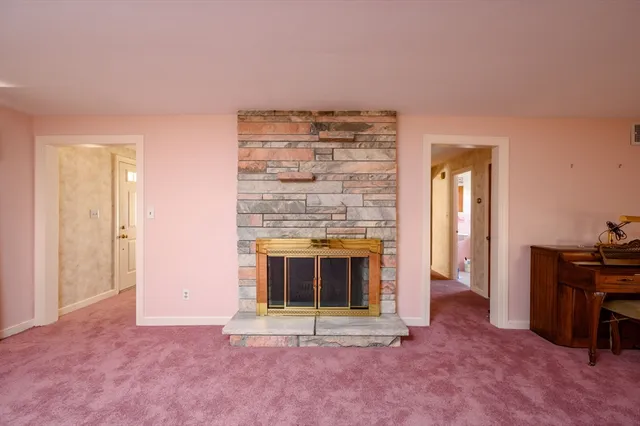 a view of an empty room with a fireplace and a window