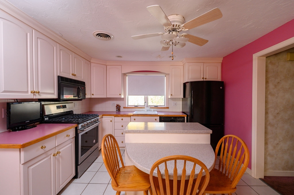 61 Grove Street Braintree, MA 02184 - Photo 6 of 29 a kitchen with a appliances dining table and chairs