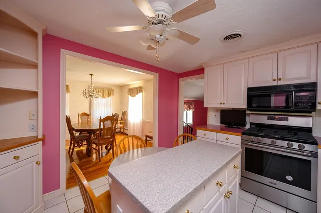 a kitchen with stainless steel appliances granite countertop a stove refrigerator and a microwave