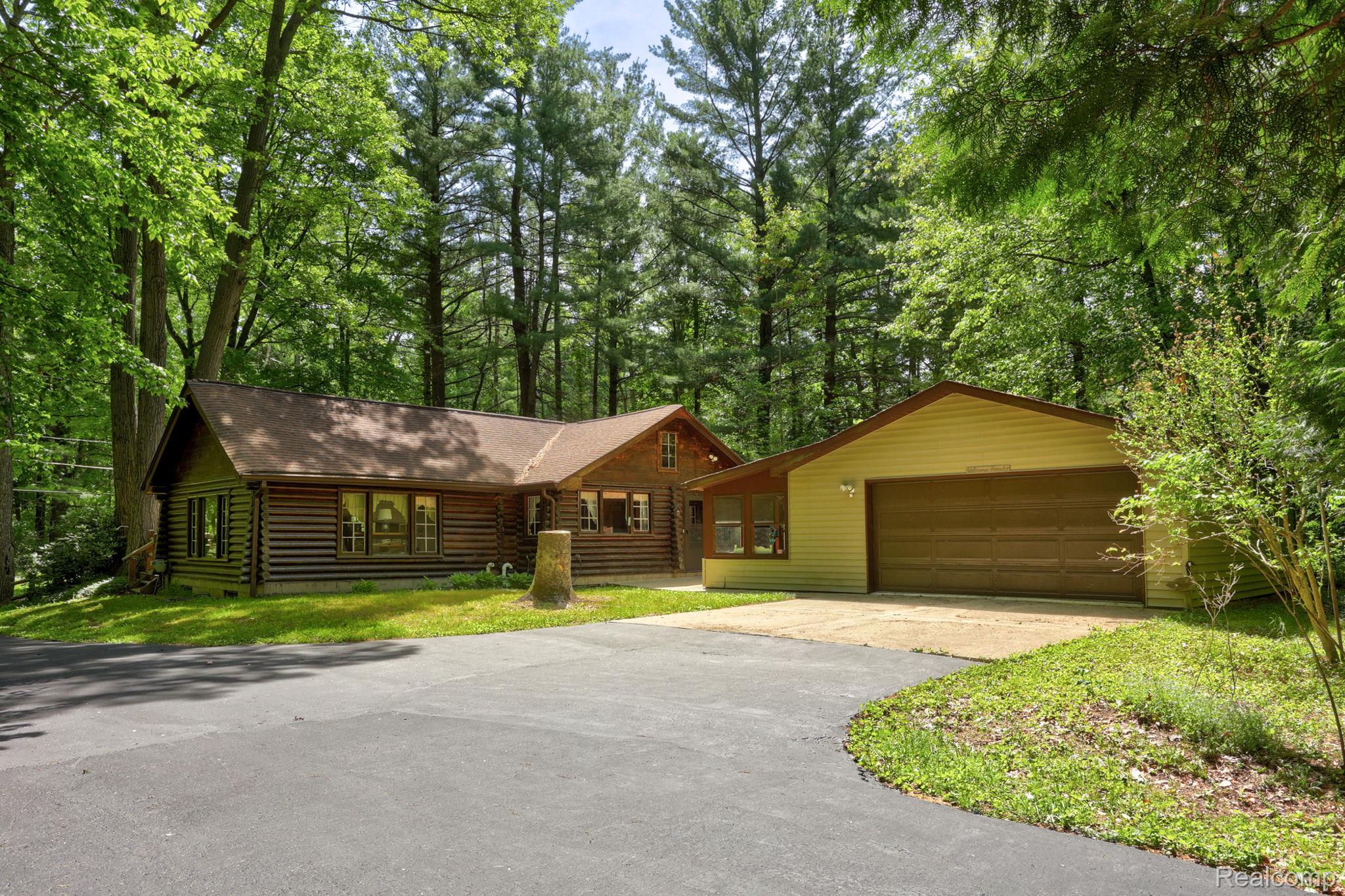 3814 South Towerline Road Bridgeport, MI 48722 - Photo 3 of 52 Log-style residence with an attached garage, surrounded by mature trees