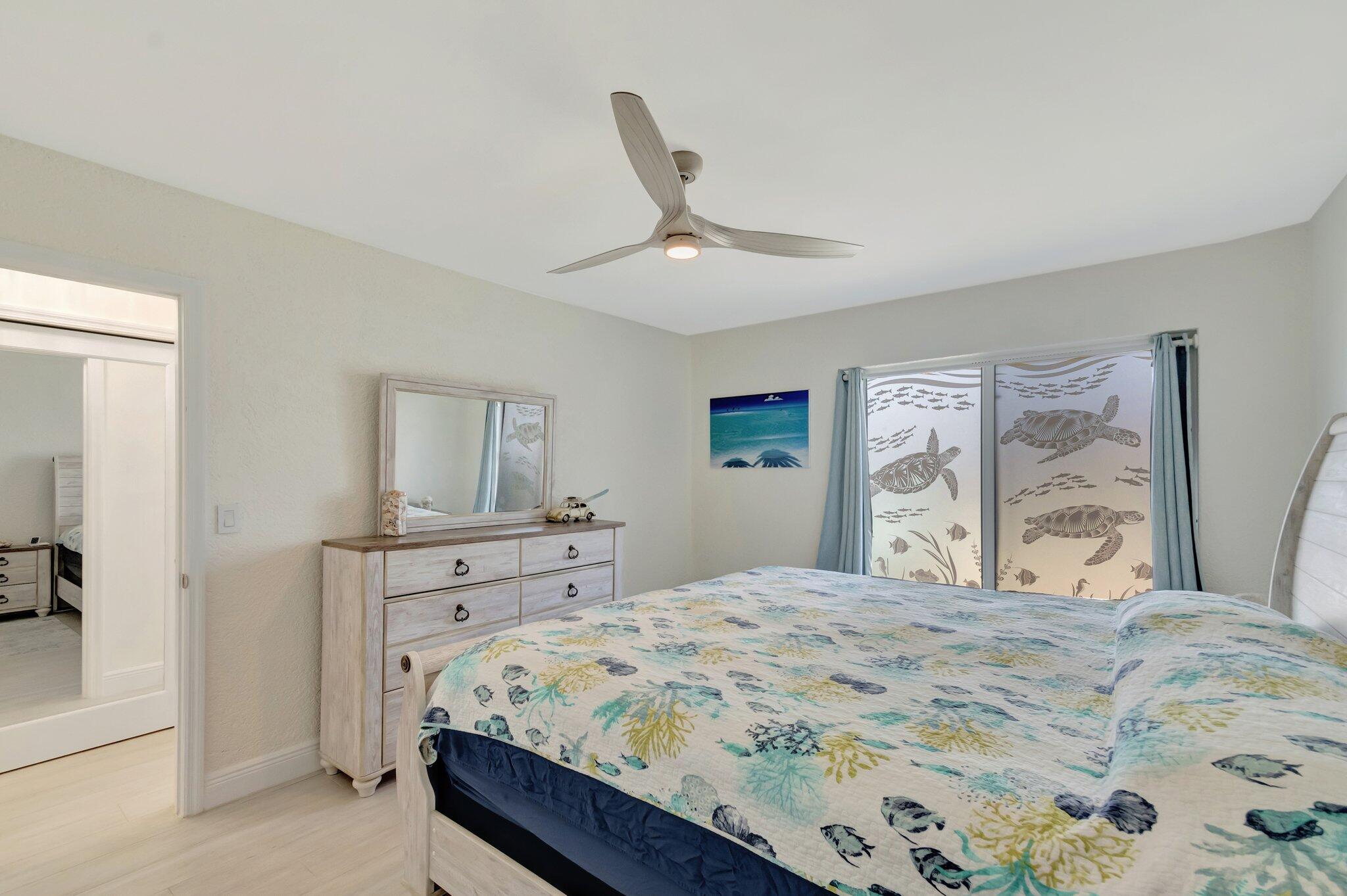 5700 Old Ocean Boulevard, Unit R Ocean Ridge, FL 33435 - Photo 11 of 20 a bedroom with a large bed and a chandelier