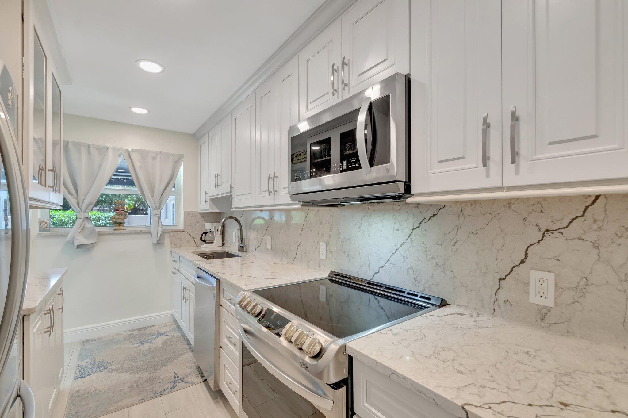5700 Old Ocean Boulevard, Unit R Ocean Ridge, FL 33435 - Photo 5 of 20 a kitchen with stainless steel appliances granite countertop a sink and a stove