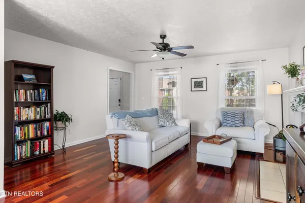 a living room with furniture wooden floor and a book shelf