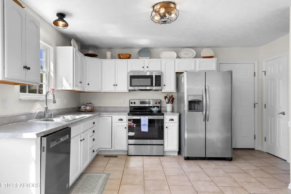 a kitchen with stainless steel appliances a stove a sink and a refrigerator