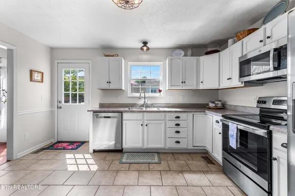 a kitchen with stainless steel appliances granite countertop a stove top oven cabinets a stove top oven a sink and dishwasher