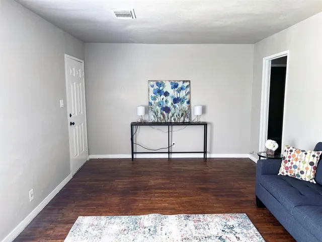 a view of a hallway with wooden floor and a bookshelf