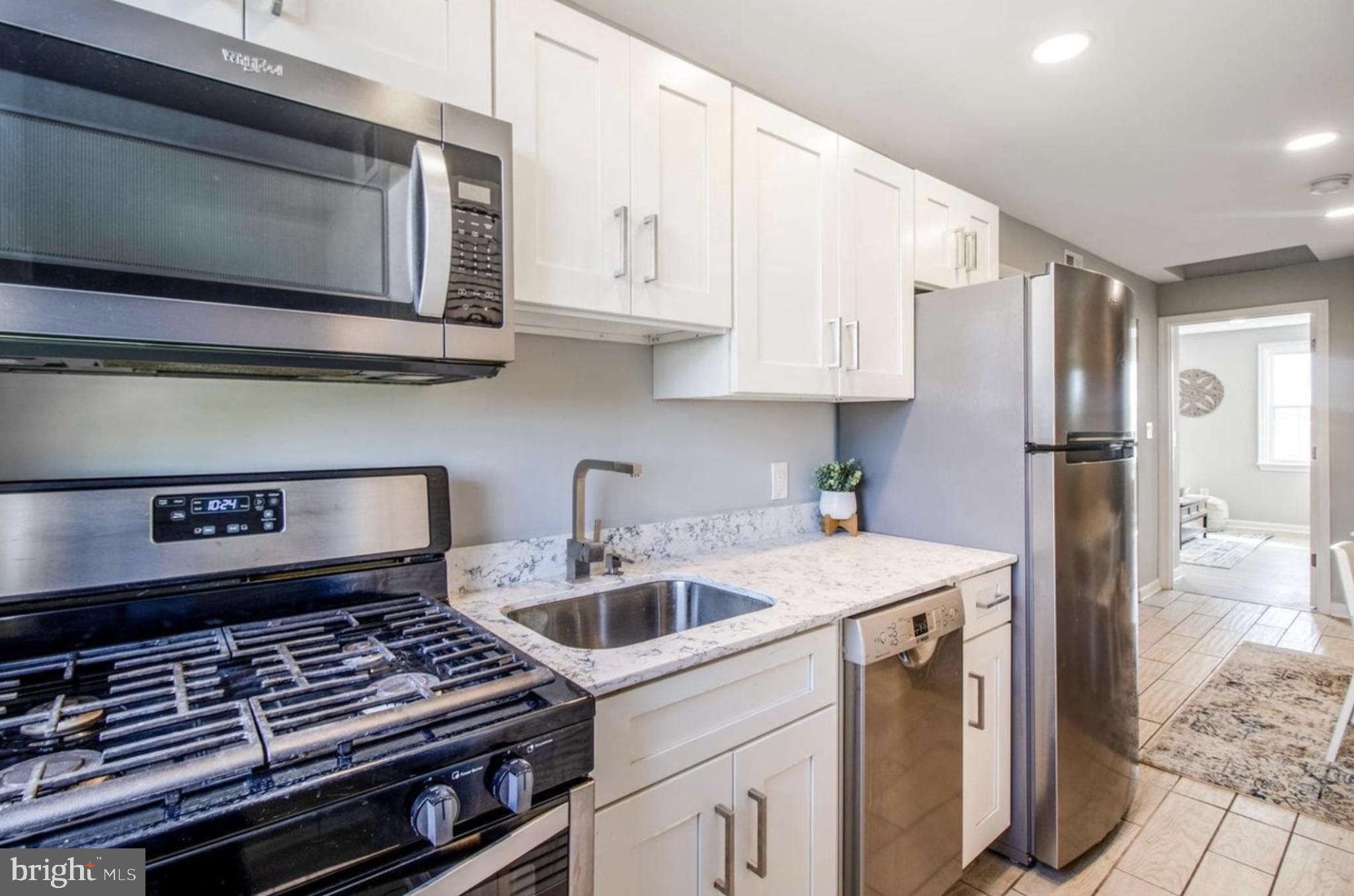 1149 Summit Street Northeast, Unit 2 Washington, DC 20002 - Photo 3 of 14 a kitchen with stainless steel appliances granite countertop a refrigerator and a stove top oven