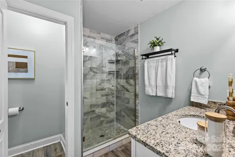 a bathroom with a granite countertop sink a toilet and shower