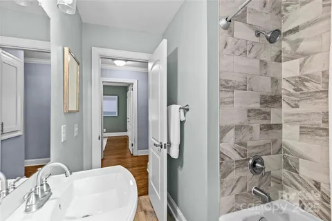 a bathroom with a granite countertop shower a sink and a mirror