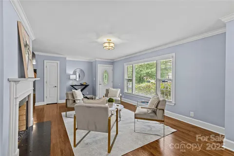 a living room with furniture a fireplace and a window