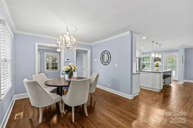 a view of a dining room with furniture a chandelier and wooden floor