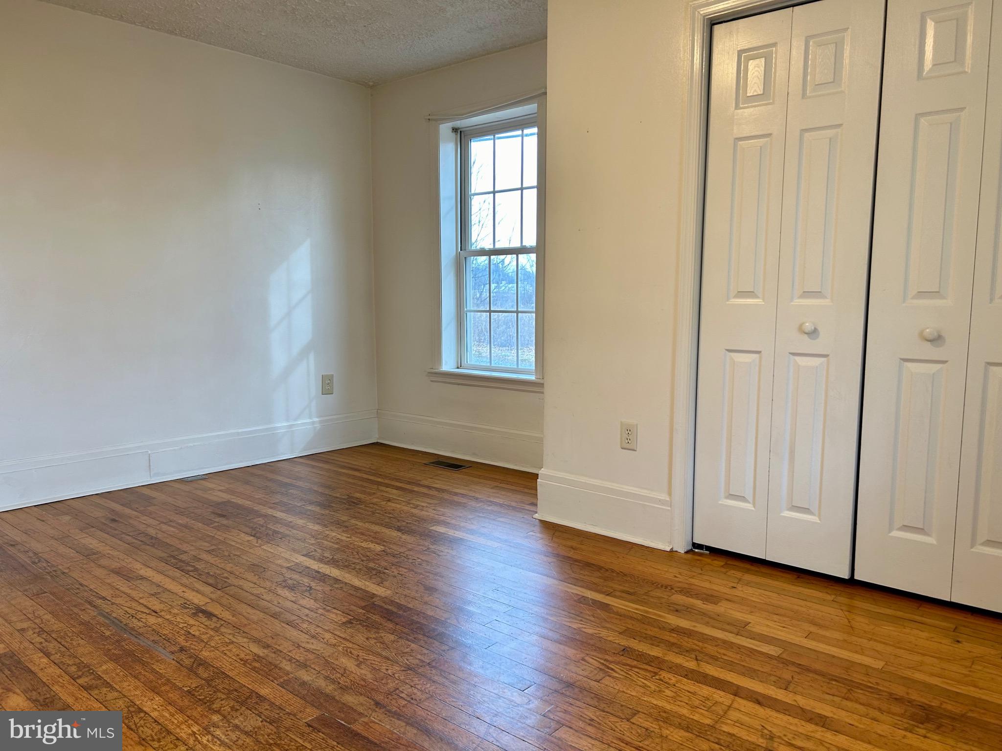 2266 Henshaw Road Inwood, WV 25428 - Photo 13 of 25 an empty room with wooden floor and windows