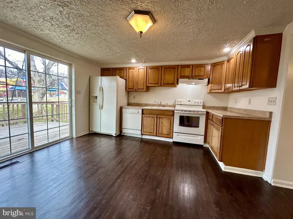 a kitchen with stainless steel appliances granite countertop a stove top oven a sink with wooden floors and cabinets