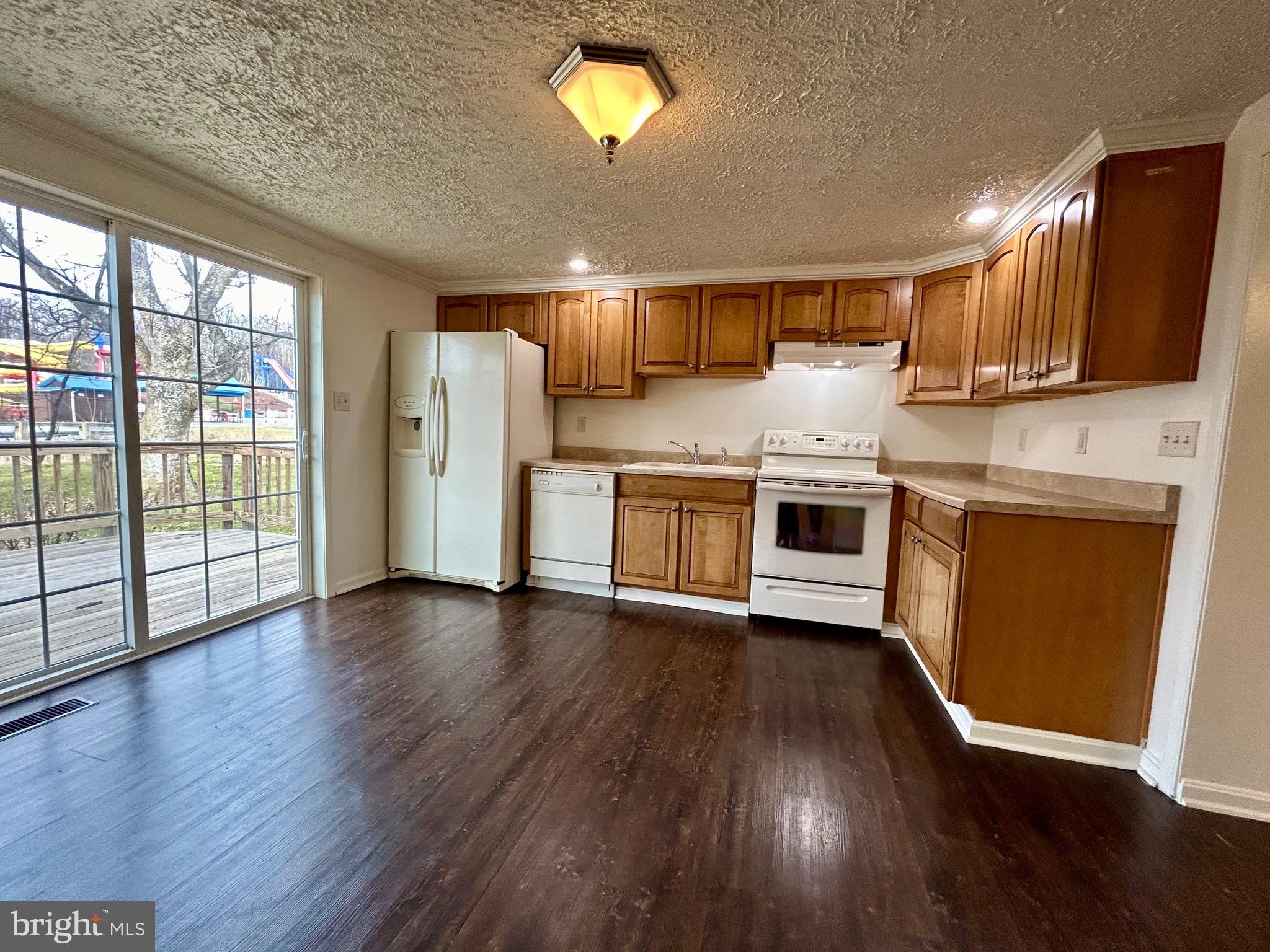 2266 Henshaw Road Inwood, WV 25428 - Photo 24 of 25 a kitchen with stainless steel appliances granite countertop a stove top oven a sink with wooden floors and cabinets